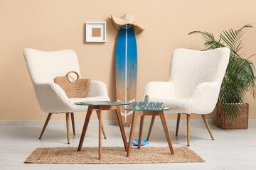 Interior of stylish living room with white armchairs, coffee table and surfboard