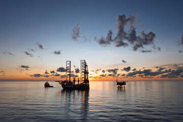 Aerial view of offshore jack up drilling rig during sunset - oil and gas industry.