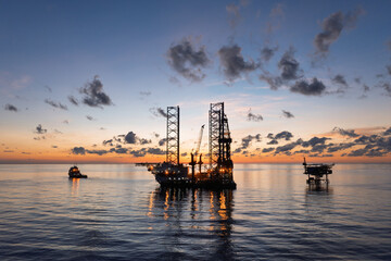 Aerial view of offshore jack up drilling rig during sunset - oil and gas industry.