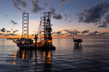 Aerial view of offshore jack up drilling rig during sunset - oil and gas industry.