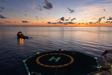 Aerial view of offshore jack up drilling rig during sunset - oil and gas industry.