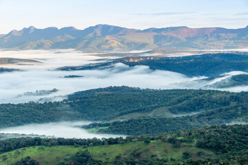 Landscape of the valley, seen from the top of the Serra da Moeda, partially covered by clouds, during the fall dawn. Brumadinho, Brazil