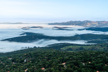 Landscape of the valley, seen from the top of the Serra da Moeda, partially covered by clouds, during the fall dawn. Brumadinho, Brazil