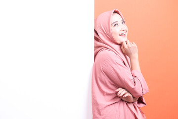 Naklejka premium Pondering Muslim Woman Next to Blank Space, A serene portrait of