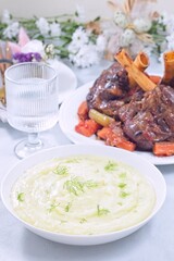 Puree or mashed potatoes with horseradish and fennel, braised lamb shanks in background, vertical