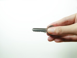 Minimalist image of a hand holding a metal key—ideal for real estate, security, access control,...