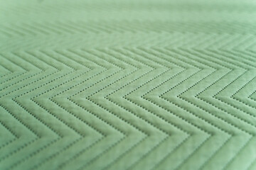 Detailed quilted green fabric with alternating zigzag geometric pattern