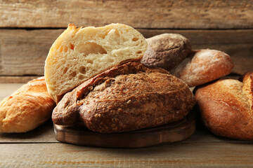 Different loaves of fresh bread on wooden table