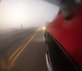 A blurry shot of a car driving down a foggy road