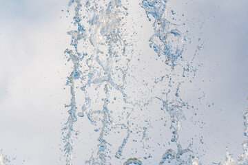 Splashes and jets of water against light background.