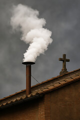 a white smoke from chimney of church rooftop