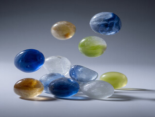 Fototapeta premium Vibrant Glass Stones Pebbles Arrangement Floating Background Decorative Transparent Oval Objects Shiny Crystal Reflective Smooth Texture Artistic Sea Pool Colorful Light Shapes Eco-Friendly Design