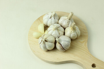 Garlic on wooden cutting board and isolated on white background. Close up.