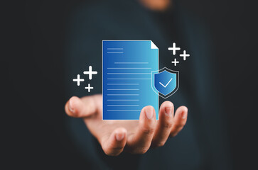 Insurance concept. Health insurance, insurance policy, accident insurance, health, home, life, travel and policy guarantee. Businessman holding document with shield protection on virtual screen.
