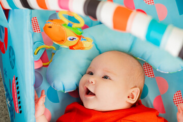 Portrait of a cute little baby boy lying in the playroom