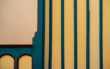 Fachada colorida con líneas verticales azules y detalles arquitectónicos coloniales
