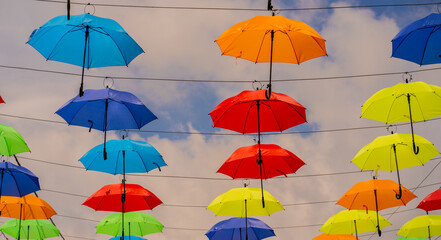 Paraguas de colores colgantes decorando el cielo en instalación artística urbana - foto de stock 