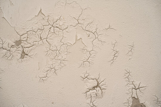 Textura de pared con pintura cuarteada y desgaste visible por paso del tiempo