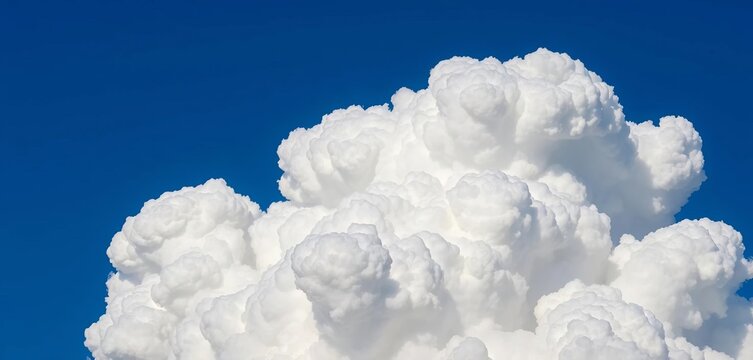 Close-up of a brilliant white cumulonimbus cloud top against a deep blue sky, atmospheric, environment