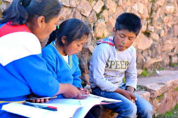 Aymara kids learning with the teacher in the countryside.
