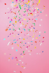 Birthday, party, celebration, New Year or Christmas celebration concept. Multicolored confetti falling against pastel colored pink background , with white tonespng