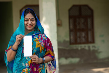 Portrait of Indian rural young woman showing unique identity card at village. Indian rural woman...