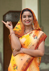 Indian rural woman pointing finger at home