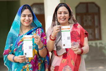 Portrait of Indian rural women showing showing unique identity card at village. Indian rural woman...