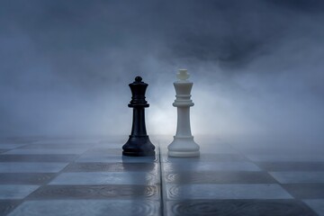 Black and White Chess Queens face off on a misty game board a strategic battle of wits and power