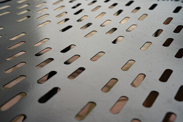 Close-up of a perforated metal surface with a sleek, modern design.