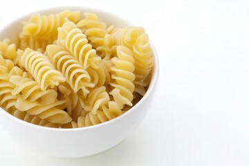 White bowl of plain cooked rotini pasta on white background
