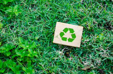 Top view of Recycle symbol on wooden block with customizable space for text. For a greener tomorrow...