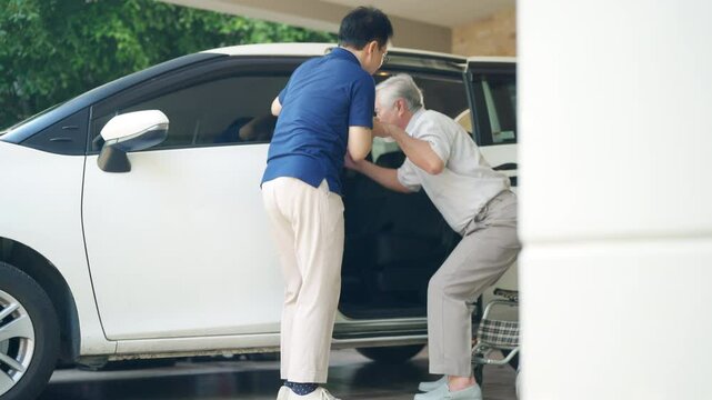 Asian man caregiver or taxi driver helping senior man patient get in the car to get to medical appointments or healthcare therapy sessions at hospital. Assisted elderly patient transportation services