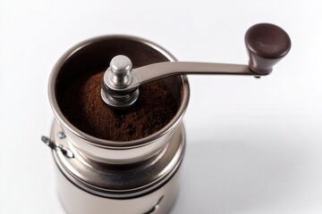 Manual coffee grinder with freshly ground coffee and beans on white background
