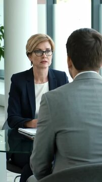 Job interview between two professionals in a modern office setting, vertical footage