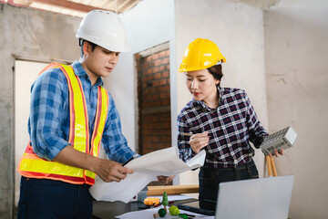 Engineers and contractors inspect construction plans indoors, using technology and equipment to...
