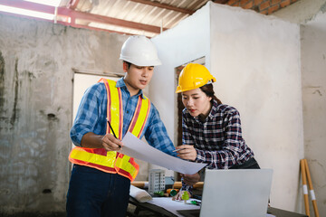 Engineers and contractors inspect construction plans indoors, using technology and equipment to...
