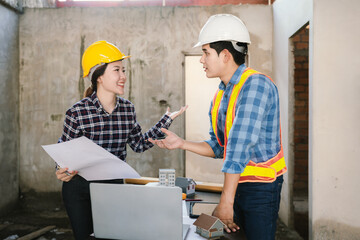 Engineers and contractors inspect construction plans indoors, using technology and equipment to...