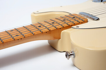 Six-string electric guitar, with a cream-colored wooden body and chrome-plated fittings.