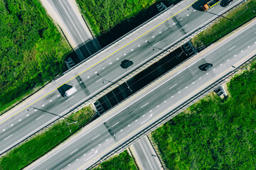 Aerial drone view of highway asphalt road with cars and cargo trucks.