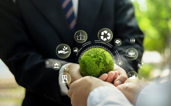 Businessman holding a green digital globe representing global business and technology connections