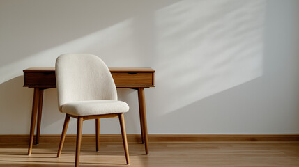 A solitary beige chair in front of a blank wall and desk