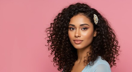 Portrait of a charming young woman with voluminous curls and hair accessory