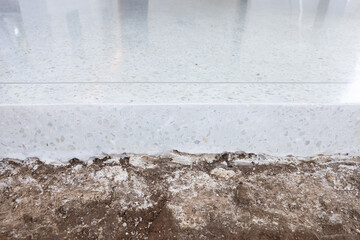 Terrazzo floor at side view. Floor finishing material. Construction for decorative surface by cover on concrete floor. Clean white bright and shiny surface. Nobody empty space suit for background.