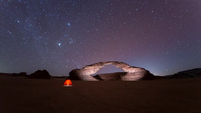 4k Time lapse of stars motion in rainbow arch night camping tent, with beautiful rock Al ula, Madinah,  Saudi Arabia