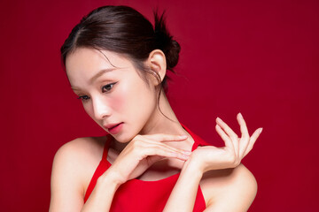 赤い背景で撮影をした若い女性のアジアンビューティーイメージ
