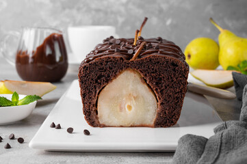 Chocolate pie or cake with whole pears and chocolate glaze on top on gray background.