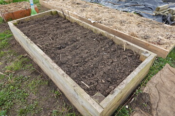 Raised garden bed filled with fertile soil ready for planting