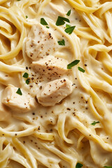 creamy chicken fettuccine Alfredo pasta with black pepper and parsley garnish, macro and full-frame texture shot, close-up texture, top view