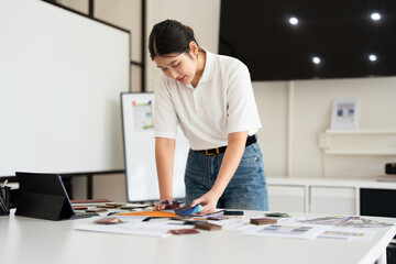 Experienced Interior designer holding color samples working on new design project at office